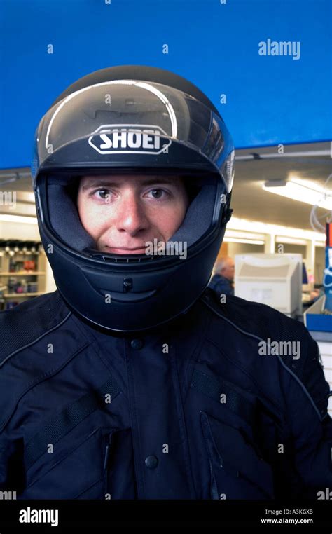 Smiling Young Man Wearing Motorcycle Helmet And Jacket With Workplace