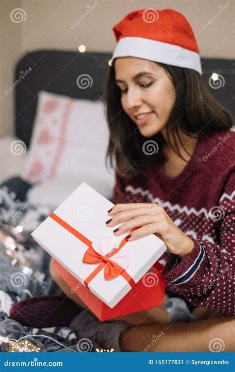 Curious Woman Looking At Her Opened Christmas Present Stock Image