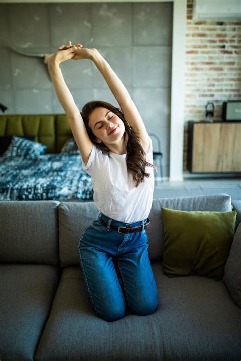 Happy Young Woman Relaxing And Stretching On Couch Thinking Of Pleasant Lazy Day Stock Image