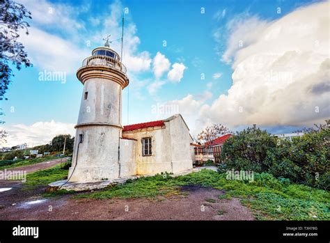 Historical Aegean Lighthouse Against A Blue Sky And Clouds Background