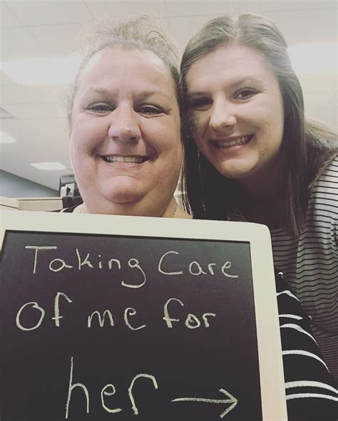 Two Women Holding Up A Sign That Says Taking Care Of Me For Her