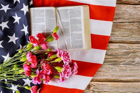 Us Flag With Praying Over A Open Reading Holy Bible On A Close Up Of
