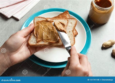 Woman Spreading Cream Cheese On Crispy Toast Bread On Purple Background Stock Photography
