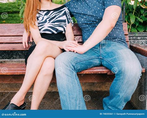 Young Couple Holding Hands While Sitting On The Bench Stock Image
