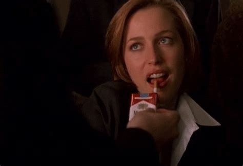 A Woman Holding A Candy Bar In Her Mouth