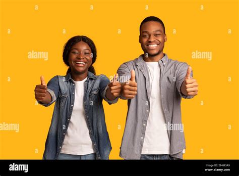 Lo recomendamos Retrato de alegre pareja africana gestuando pulgares hacia arriba en la cámara