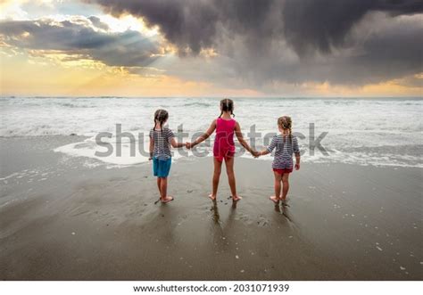 Three Girls Holding Hands Beach Looking Stock Photo 2031071939