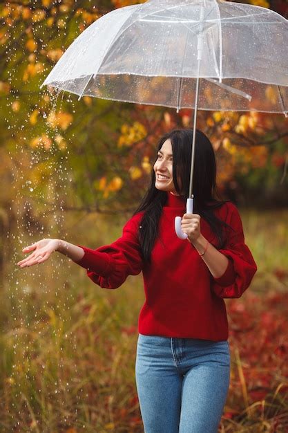 Premium Photo Beautiful Woman Holding An Umbrella In The Rain And Smiling