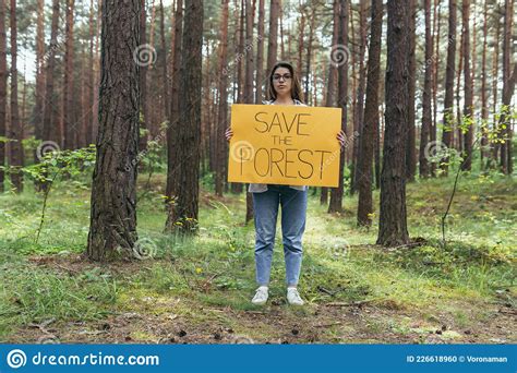 Young Woman Volunteer In The Woods Pickets And Holds A Poster Save The