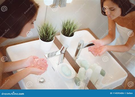 Young Woman Washing Her Face With Clean Water In Bathroom Stock Photo