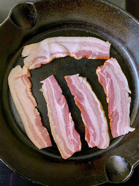 Bacon Is Being Cooked In A Frying Pan