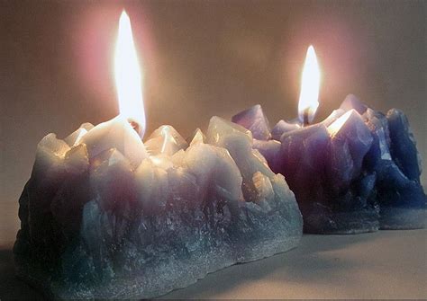Two Candles With Ice On Them Sitting Next To Each Other