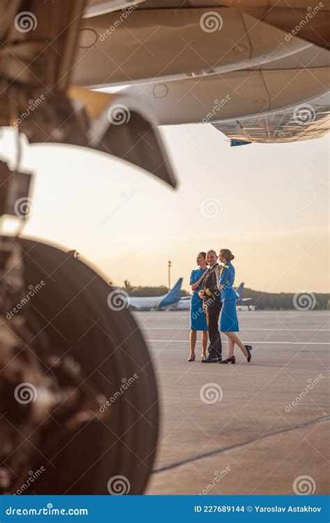 Full Length Shot Of Male Pilot Posing For Photoshoot Together With Two
