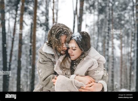 Love Romantic Young Couple Guy Hugging Kissing Girl In Snowy Winter Forest Walkinghaving Fun
