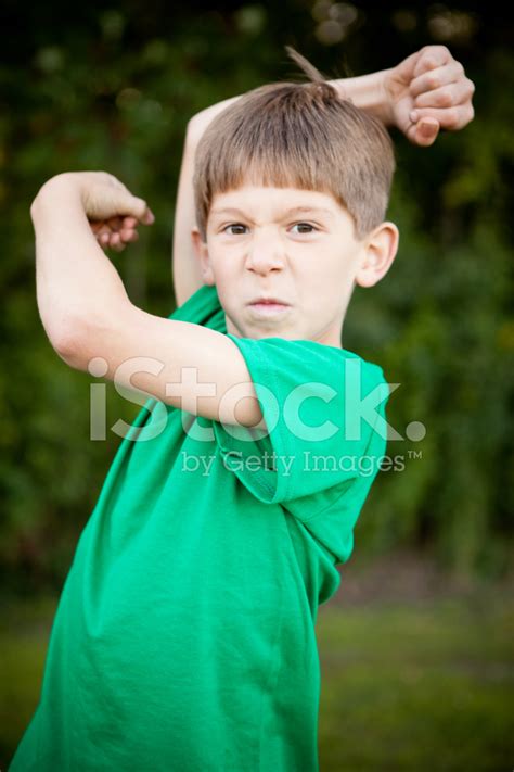 Tough Young Boy Flexing His Muscles Outside Stock Photos