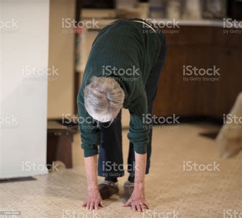 Senior Woman Bending Over To Touch Floor Stock Photo Download Image