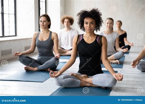 Professional Young Female Mixed Race Trainer Leading Yoga Class Stock