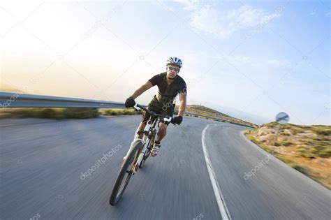 Cyclist Man Riding Mountain Bike In Sunny Day On A Mountain Road Stock Photo Juananbarros