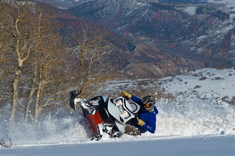 Snowmobile In Powder Carving Tight Turn With Mountains Background Stock
