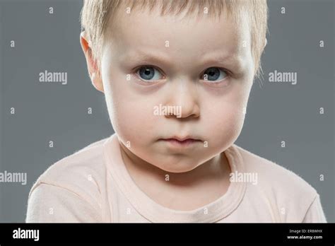 Angry Boy Looking Away Against Gray Background Stock Photo Alamy