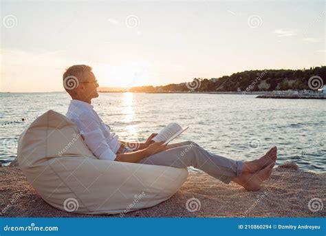 Man Reading A Book Lying On Deck Chair On The Beach During Sunset Stock Photo Image Of Hair