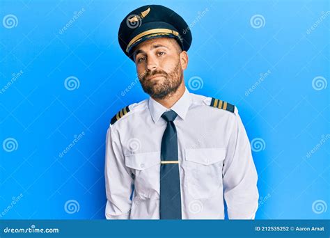 Handsome Man With Beard Wearing Airplane Pilot Uniform Relaxed With
