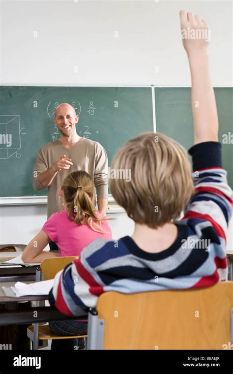 Rear View Of A Boy Raising His Hand In A Classroom Stock Photo Alamy