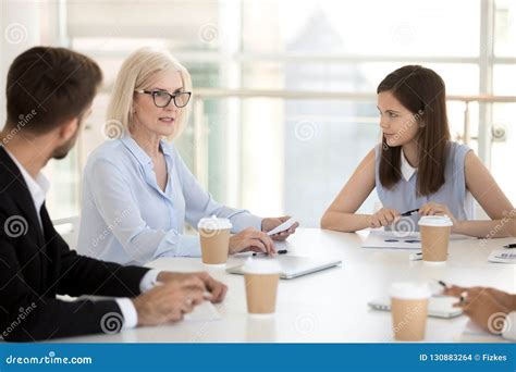 Young Employees Listen To Female Boss Talking During Briefing Stock