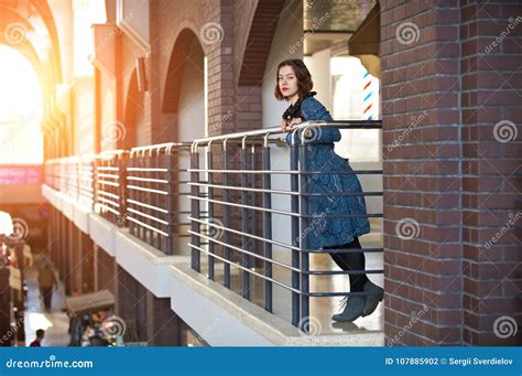 Portrait Of A Happy Young Woman Standing In The Hall At Sunset Stock
