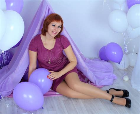 Beautiful Long Legged Redhead Girl In Violet Dress And Shiny Stockings Posing At The Ball Stock