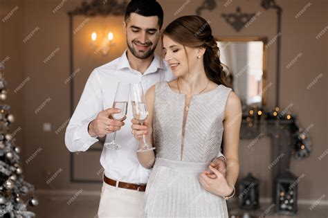Нарядно одетые мужчина и женщина в серебряном платье обнимают друг