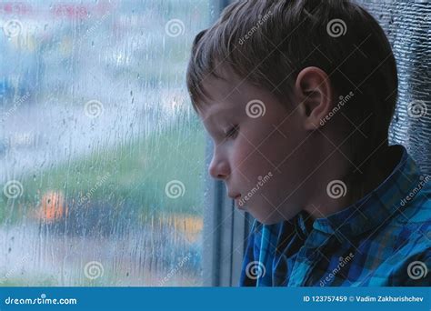 Boy Looks Out The Window In The Rain And Is Sad Stock Image Image Of