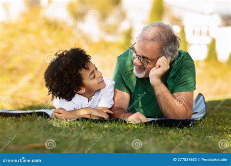 Glad Little Mixed Race Kid And Old Caucasian Grandfather Talking Enjoy