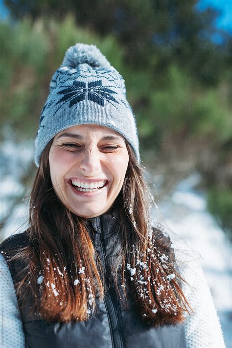 Portrait Of A Young Woman Smiling With Snow In Her Hair By Stocksy