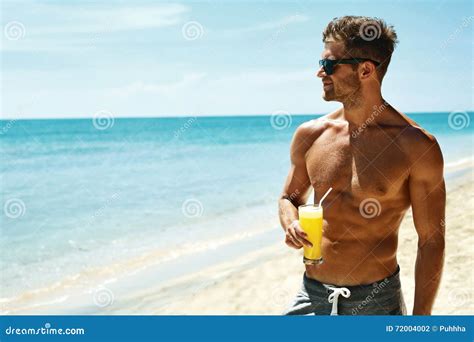 sommer athletischer muskulöser mann der juice cocktail on beach trinkt stockfoto bild von