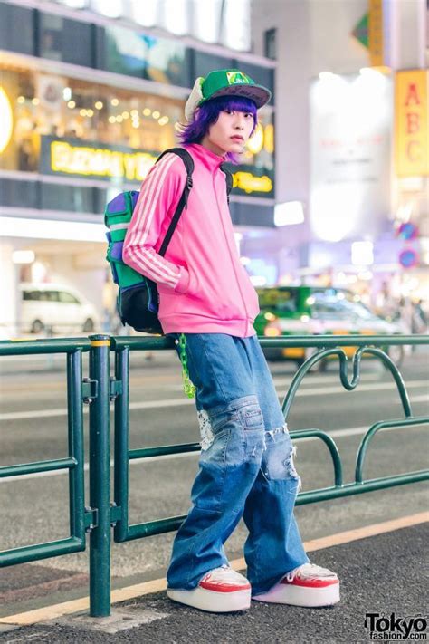 purple haired harajuku guy in colorful streetwear w adidas jacket and platform sneakers tokyo