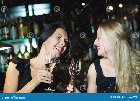Two Female Friends Toasting In A Nightclub Stock Photo Image Of