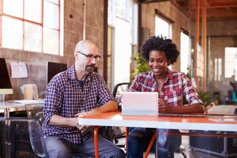 Twee Ontwerpers Sit At Meeting Table Working Op Digitale Tablet Stock