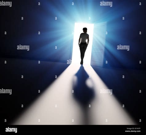 A Woman Walking Into The Light Through Open Door Stock Photo Alamy