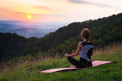 Woman Doing Yoga Meditation In The Mountains At Dawn Stock Photo