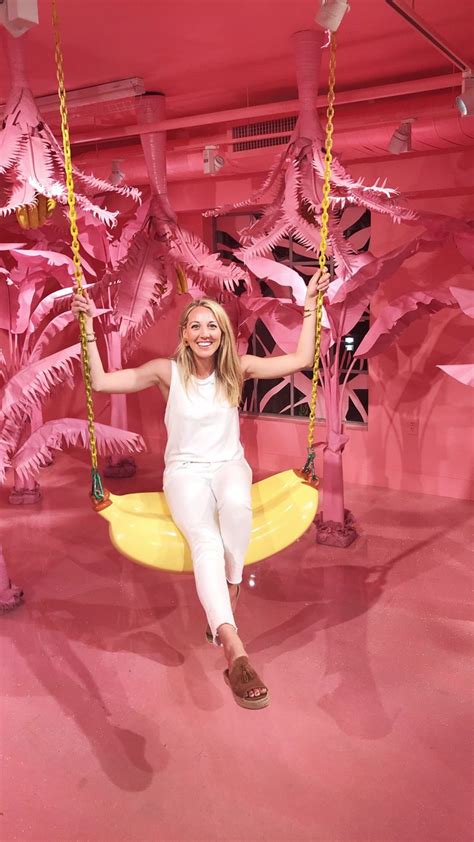 A Woman Sitting On A Yellow Swing In A Pink Room