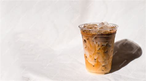Premium Photo Closeup Plastic Cup Of Iced Coffee With Milk On The Table