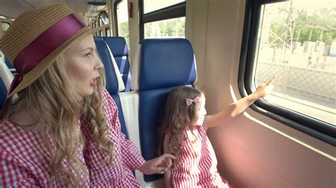 Happy Mom And Daughter Traveling Together Goes On The Train And Look