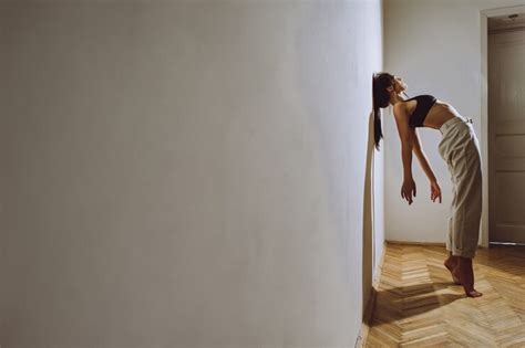 premium photo a beautiful girl leaning against the wall in the room as a barrier in life