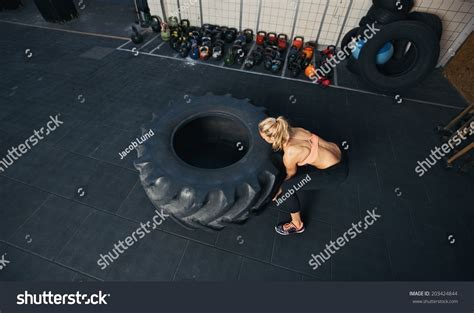 Top View Of Young Female Flipping Heavy Tire Woman Doing Crossfit