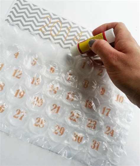 Wrap the box with plain paper with the standard gift wrapping method, finishing with the triangle flap folds over the side. DIY Bubble Wrap Calendars | A Joyful Riot