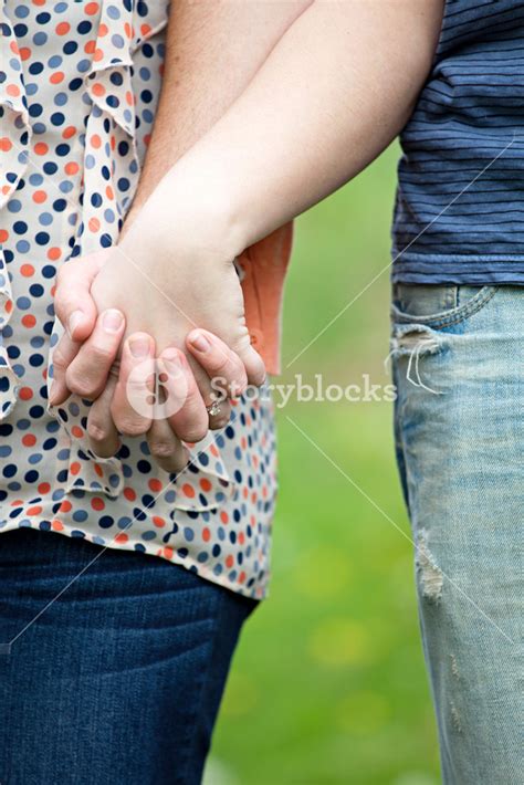 Close Up Of A Young Happy Couple Holding Hands Together At Waist Height Royalty Free Stock