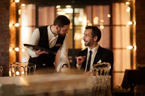 Premium Photo Smiling Businessman Talking To Waiter In Restaurant