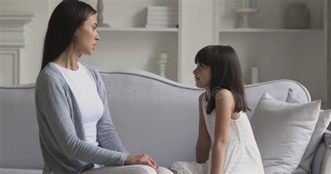 Angry Young Adult Mother Scolding Stubborn Child Daughter At Home Stock