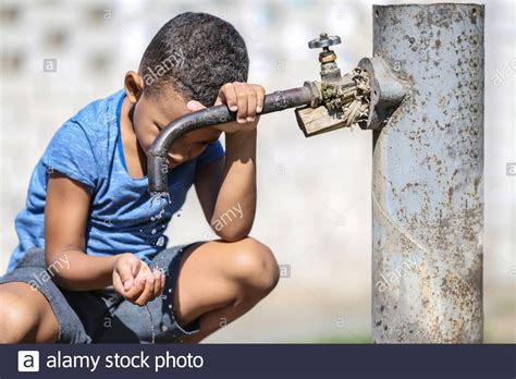 African American Child Drinking Water From Tap Outdoors Water Scarcity